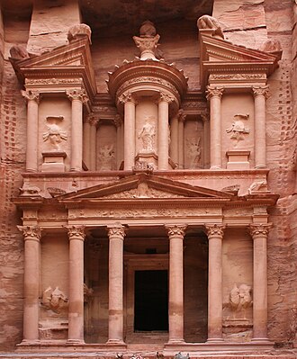 The Treasury at Petra carved into rose-red cliffs in Jordan